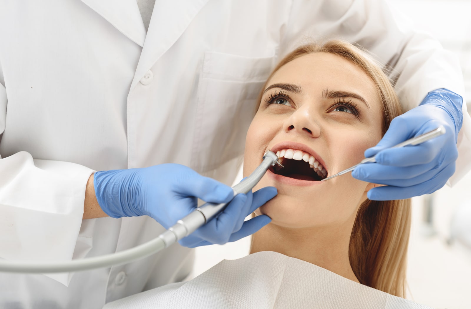 A woman getting her teeth cleaned by a dentist