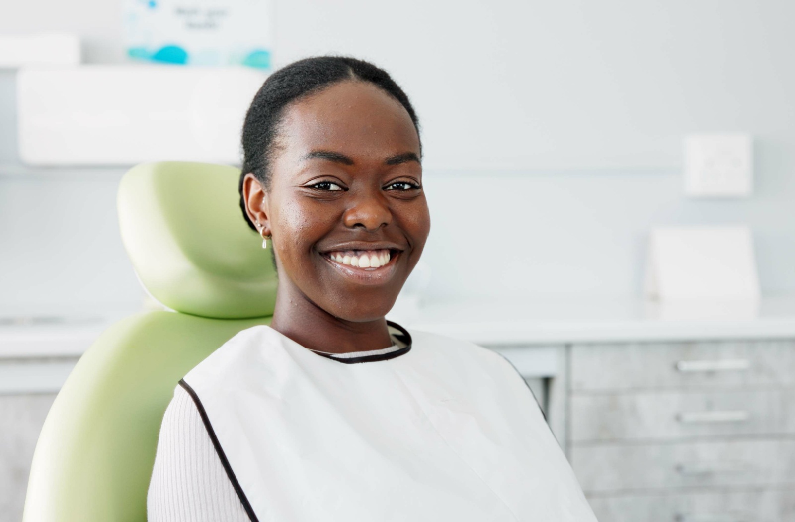 a woman just finished her whitening treatment at her dentist's office.