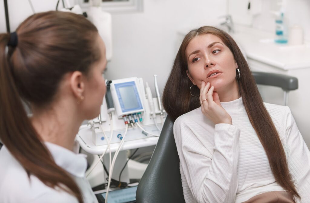 An adult explains to their dentist how they're experiencing pain in their mouth.