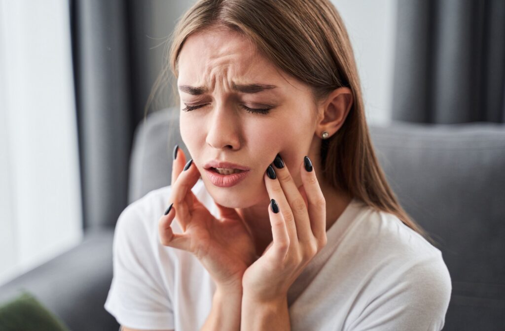 A close-up image of an adult experiencing discomfort, possibly due to tooth decay they haven't noticed.