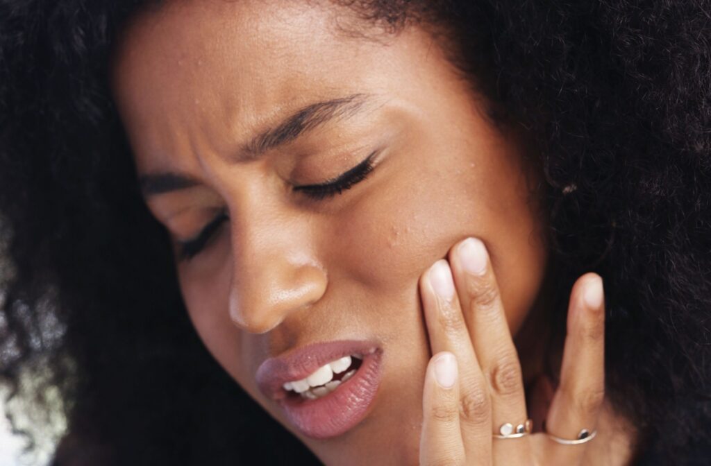 A person holding the side of their jaw in pain.